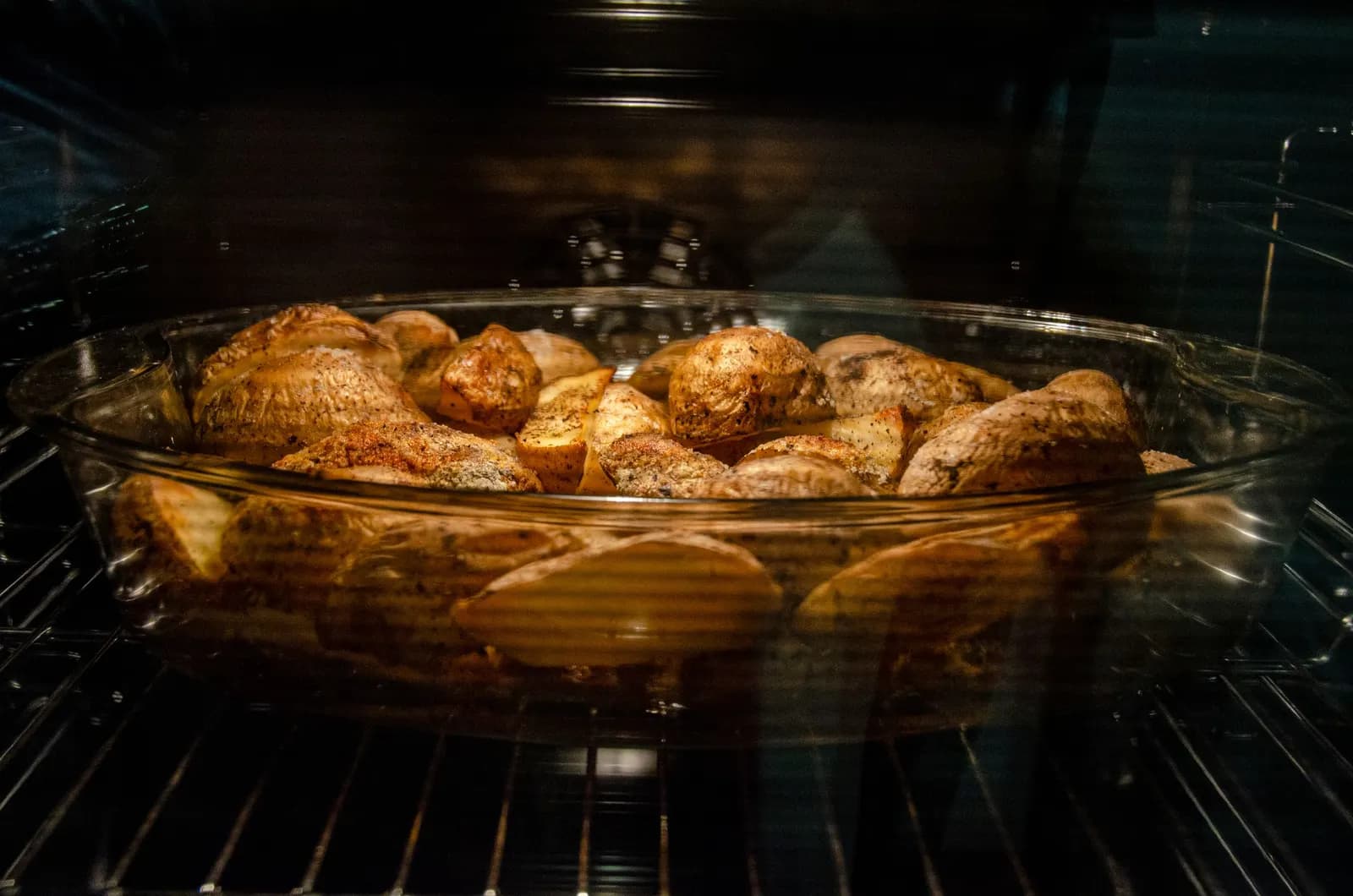Bandeja de patatas asándose dentro de un horno eléctrico