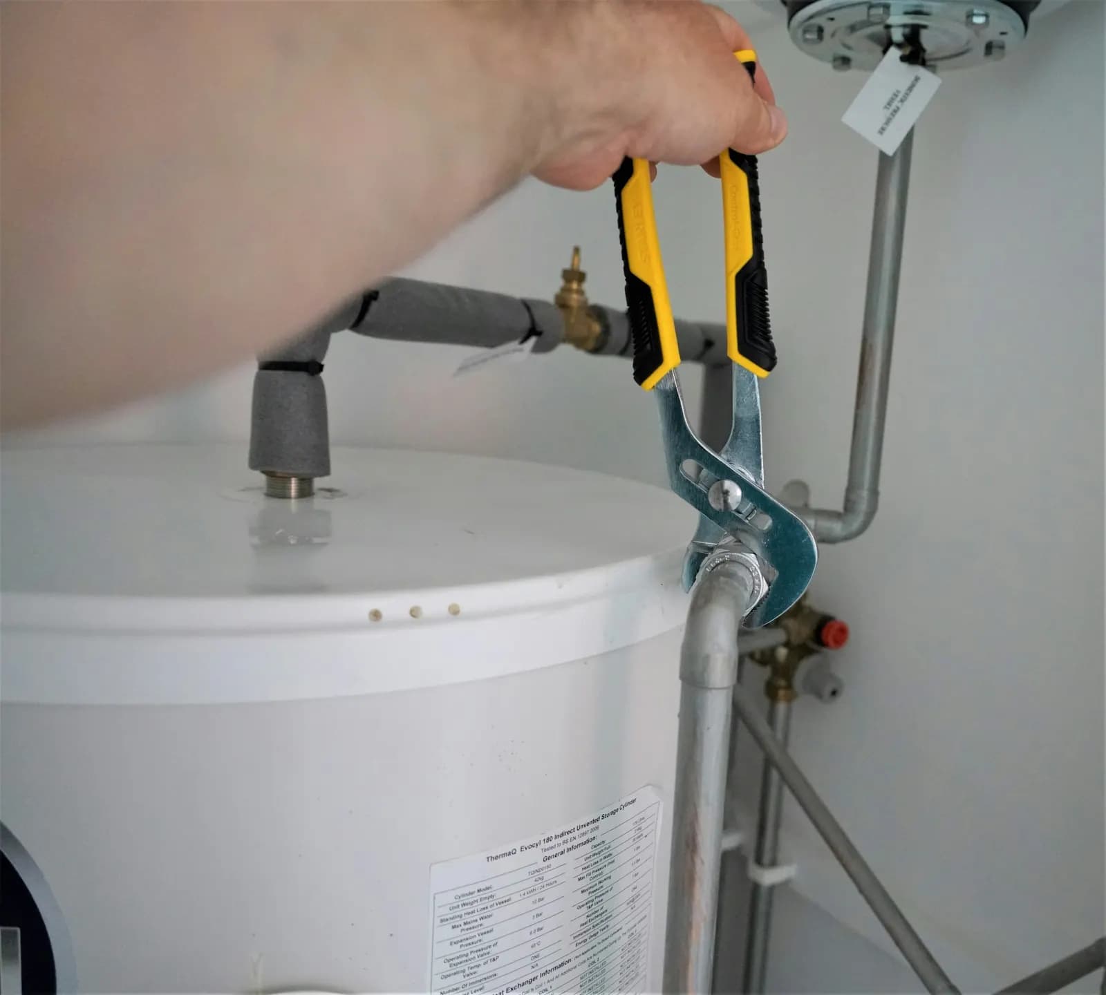Técnico apretando la conexión de un termo eléctrico con una llave