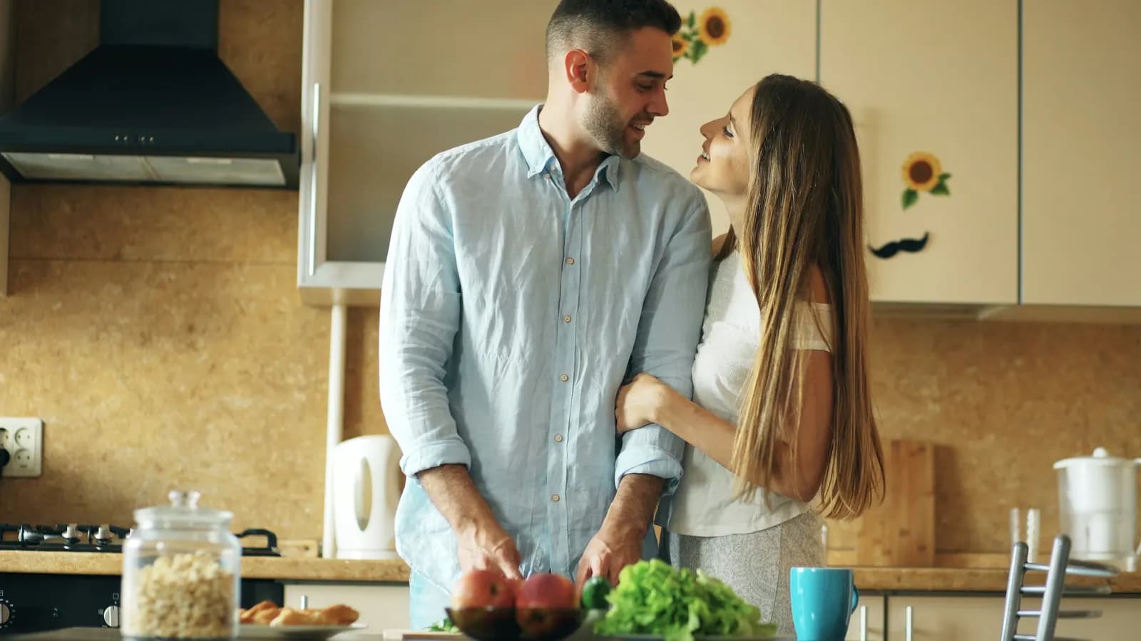 Pareja contenta en su cocina tras la reparación de sus electrodomésticos